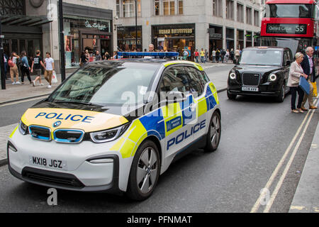 London, Großbritannien. 22 August, 2018. Teil der Bemühung, die Luft in der Oxford Street zu reinigen beinhaltet die Einführung von Elektro- oder Hybridfahrzeuge - in diesem Fall ein BMW elektrische Polizei Auto, eine der neuen elektrischen schwarzen Londoner Taxis und ein hybrid Double Decker London Bus. London, 22. Aug 2018. Credit: Guy Bell/Alamy leben Nachrichten Stockfoto