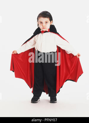 Ein Junge verkleidet als Vampir in einem schwarzen und roten Mantel Stockfoto