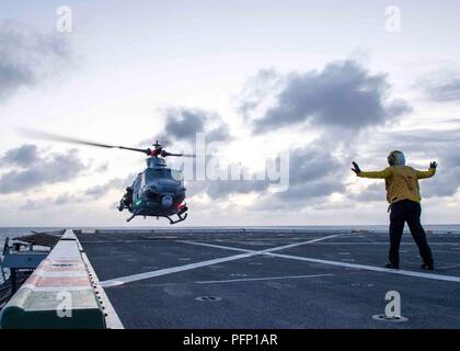 180727-N-PH 222-0099 PAZIFISCHER OZEAN (27. Juli 2018) der Luftfahrt Bootsmann Mate (Handling) Airman Eddie De La Cruz, von Garden Grove, Kalifornien, Signale Ein UH-1Y Venom Hubschrauber, zugeordnet zu den Marine Light Attack Helicopter Loslösung der Marine Medium Tiltrotor Squadron (VMM) 166, auf dem Flugdeck von San Antonio zu Land-Klasse amphibious Transport dock USS Anchorage LPD (23), die während einer planmäßigen Einsatz von Essex Amphibious Ready Group (ARG) und 13th Marine Expeditionary Unit (MEU). Das Essex ARG/MEU Team ist eine starke und flexible Kraft ausgestattet und skalierbar zu reagieren auf jede Krise reichen. Stockfoto