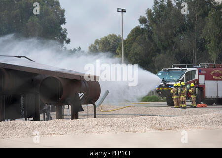 Mitglieder des 39. Bauingenieur Squadron Feuerwehr nutzen einen Absturz Ausschreibung, die eine simulierte Flugzeuge Brand in Incirlik, der Türkei, August 7, 2018. Die Feuerwehr Mitglieder verwendet die Ausübung der Reaktionszeit und der Praxis mit ihren Anlagen zu verringern, um sicherzustellen, dass sie ausreichend ausgebildet. (U.S. Air Force Foto: Staff Sgt. Kimberly Nagle) Stockfoto