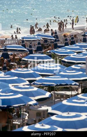 Frankreich, Nizza, Promenade des Anglais, belebten Strand mit hellen blauen Schirme Stockfoto