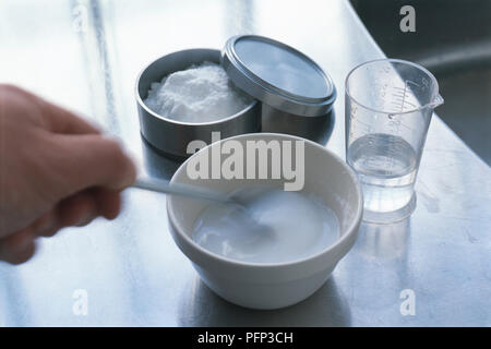 Die Natron einfügen, das Mischen von Pulver mit Wasser in der Schüssel, close-up Stockfoto