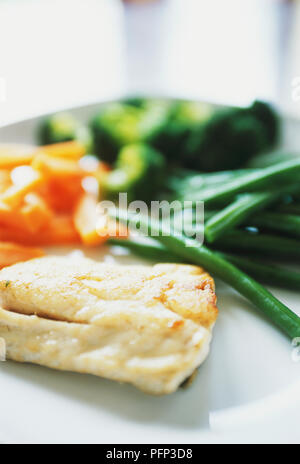 Kleines Stück gegrillter Fisch mit Auswahl von gedünstetem Gemüse, defokussiert, close-up Stockfoto