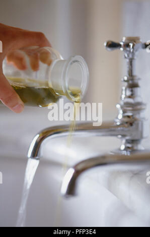 Gießt Öl in Badewanne, Badewanne, Wasser läuft von Wasserhähnen, verschwommene Bewegung Stockfoto