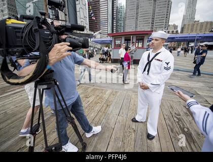 NEW YORK (23. Mai 2018) Musiker 2. Klasse Carl Schultz von Detroit, Michigan, in die US-Flotte Kräfte Band zugewiesen spricht mit einem Reporter vor einem Konzert in South Street Seaport in New York City während der Fleet Week New York 2018. Jetzt in seinem 30. Jahr, Fleet Week New York ist die Stadt der altehrwürdige Feier auf das Meer. Es ist eine einmalige Chance für die Bürger von New York und die umliegenden Tri-state-Area zu treffen Seemänner, Marinesoldaten und Küstenwache sowie Zeugnis aus erster Hand die neuesten Funktionen der heutigen Maritime Services. Stockfoto