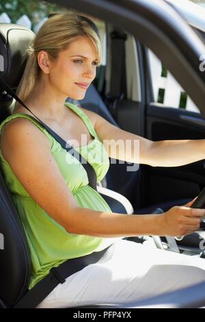 Schwangere Frau im Auto mit Sicherheitsgurt, Seitenansicht Stockfotografie  - Alamy