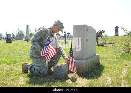 Sgt. Peter Stephenson, aus seiner 543 Composite Supply Company, 548th bekämpfen Sustainment Unterstützung Bataillon, 10 Mountain Division Sustainment Brigade, war unter den 10 Mountain Division (LI) Soldaten einpflanzen Flags 24. Mai auf Friedhöfen in der "Verlorene Orte" in Fort Drum entfernt Stockfoto