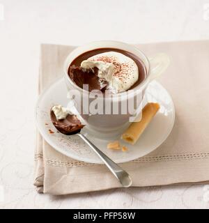 Schokolade Cappuccino pudding serviert in Schale, mit Biskuit und Löffel, auf eine Serviette Stockfoto