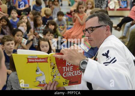 BROOKLYN, NY (24. Mai 2018) Feuer Controlman 2. Klasse Brian Keenan, aus Philadelphia, liest für Kinder in der Brooklyn Public Library während der Fleet Week New York 2018. Jetzt in seinem 30. Jahr, Fleet Week New York ist die Stadt der altehrwürdige Feier auf das Meer. Es ist eine einmalige Chance für die Bürger von New York und die umliegenden Tri-state-Area zu treffen Seemänner, Marinesoldaten und Küstenwache sowie Zeugnis aus erster Hand die neuesten Funktionen der heutigen Maritime Services. Stockfoto