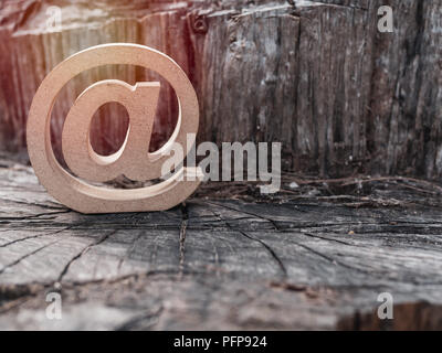 Holz- E-mail Adresse Symbol, arroba Symbol auf alten trockenen Baumstumpf Textur Hintergrund. E-mail Marketing online Internet, Technologie und Umwelt. Stockfoto