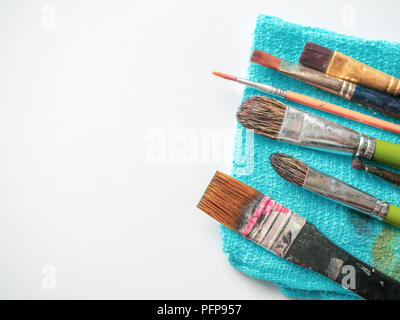 Reihe der Künstler Pinsel auf Blau kleines Handtuch auf weißem Hintergrund mit Kopie Raum isoliert. Stockfoto