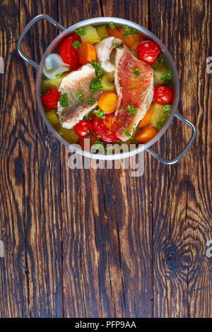 Herzhafte Fischsuppe - Griechische psarosoupa in eine Kasserolle auf einem alten Holz- rustikalen Tabelle, Ansicht von oben, flach, kopieren Platz Stockfoto