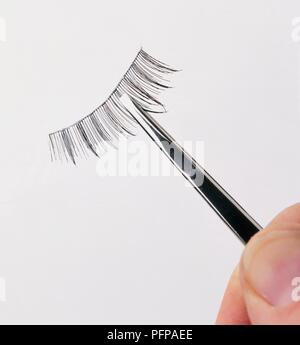 Holding falsche Wimpern und Augenbrauen Pinzette, close-up Stockfoto