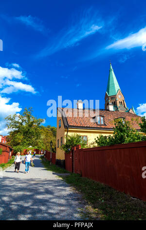 Alte Schwedische Haus und roten Zaun mit dem Sofia Kirche im Hintergrund im Vitabergsparken, Södermalm, Stockholm, Schweden Stockfoto