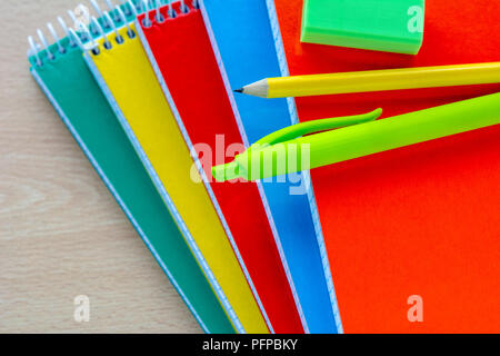 Zurück Konzept zur Schule, Schulbedarf, Blick von oben auf die bunten Schreibblock und Bleistift Stockfoto