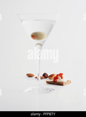 Ein Glas Martini mit grüner Olive. Stockfoto