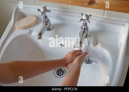 Frau Waschen der Hände im Waschbecken im Bad, close-up Stockfoto