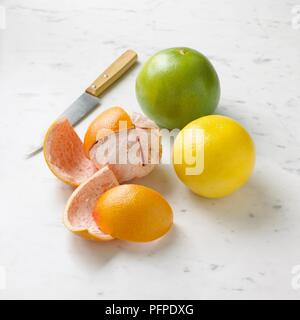 Orange, Grapefruit und Pampelmuse mit Schale und Messer, close-up Stockfoto
