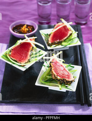 Gebratene Sesam Thunfisch mit süßen Soja und Chili Dressing auf drei Schüsseln serviert. Stockfoto