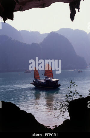 Vietnam, Halong Bucht, Drum Höhle, Junk-Schiff im Meer, durch die Umrisse der Höhleneingang gerahmt Stockfoto