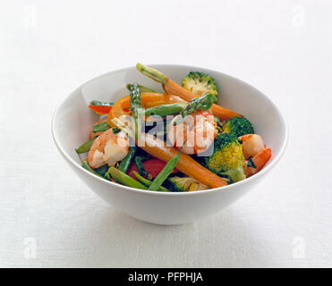 Rühren gebratener Broccoli, Garnelen, Spargel, Karotten, rote Paprika, und Französische Grüne Bohnen in Weiß Schüssel serviert. Stockfoto