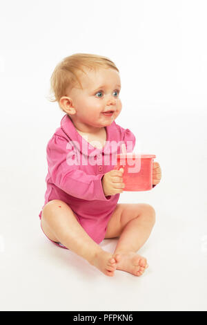 Baby in rosa Strampler trinken (Modell Alter - 9 Monate) Stockfoto