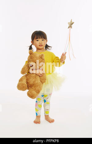 Kleines Mädchen in Fee Kostüm spielen mit Bär (Modell Alter 2 Jahre) Stockfoto