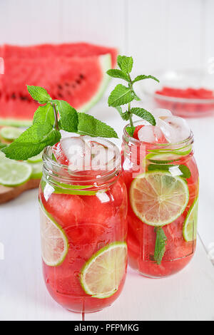 Zwei Gläser erfrischenden Sommerdrink mit Wassermelone, Limette und Minze auf einem weißen Hintergrund. Konzept der gesunden Ernährung, Reinigung des Körpers, Gewicht zu verlieren. Stockfoto
