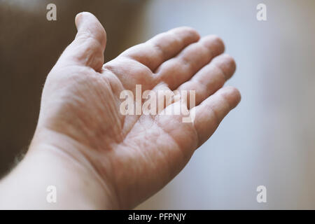 Männlich offene Hand mit leeren Handfläche nach oben, die persönliche Perspektive mit einer geringen Tiefenschärfe Stockfoto