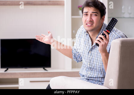 Mann, der versucht, defekte Fernseher zu reparieren Stockfoto