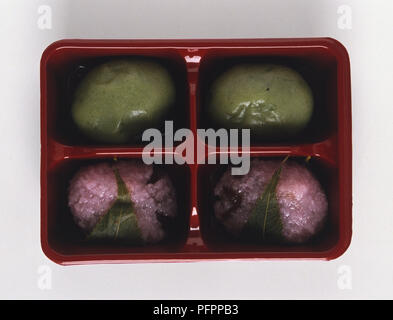 Rosa Reis Kuchen in Kirsche Blätter in einem Fach von oben betrachtet. Stockfoto