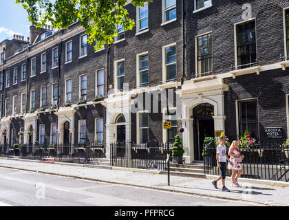 Paar in der Gower Street vor der klassischen georgianisches Stadthäusern in einem Sommer sonnigen Tag. Westminster, London, UK Stockfoto