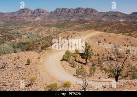 Australien, Flinders Ranges, Straße, Wicklung durch aride Terrain mit Mountain rage im Hintergrund Stockfoto