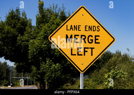 Lane enden Zusammenführen mit Bäumen und einem blauen Himmel links Stockfoto