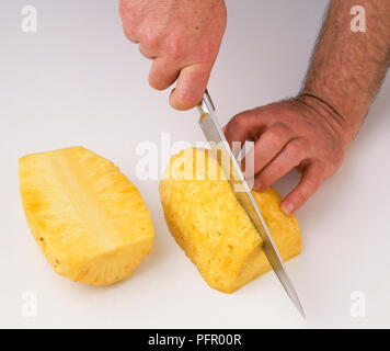 Mann mit Messer zu schneiden Ananas Stockfoto
