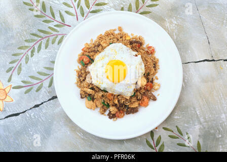 Nasi Goreng (gebratener Reis) serviert mit Spiegelei Stockfoto