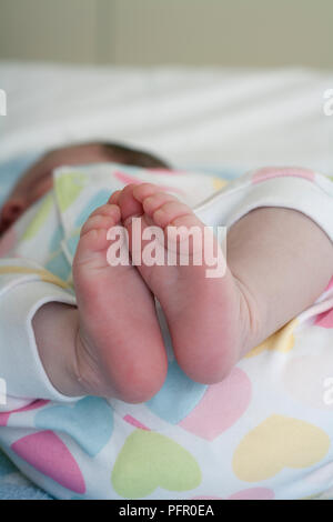 Füße von Baby schlafend in Kinderbett Stockfoto