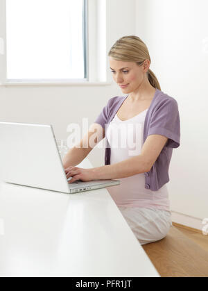 Schwangere Frau mit Laptop-computer Stockfoto
