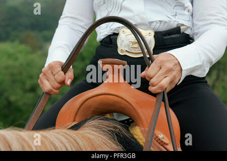 Frau auf dem Pferd die Zügel über Leder Horn auf western Sattel, close-up Stockfoto