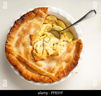 Apfelkuchen mit den betroffenen Teil der Kruste entfernt, zeigt Apple füllen und Löffel Stockfoto