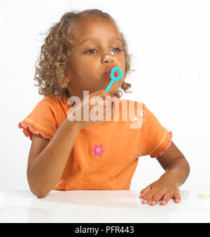 Mädchen (4 Jahre) Blasen weht durch Bubble wand, 4 Jahre Stockfoto