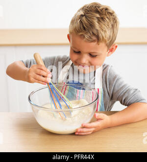 Dass nelly Brot, Junge rühren Pfannkuchenteig in eine Schüssel, 6 Jahre Stockfoto