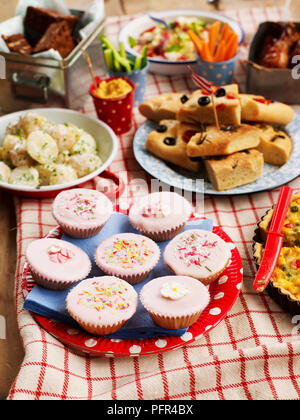 Auswahl an süßen und herzhaften Speisen, kleine Kuchen, Kartoffelsalat, Focaccia-brot, ausgebreitet auf dem Tisch, Party Food Stockfoto