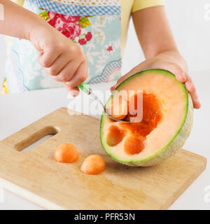 Mädchen balling eine Melone Stockfoto