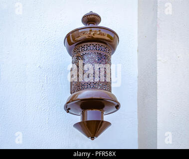 Braun, traditionelle elektrische Lampe an der Wand. Von Muscat, Oman. Stockfoto