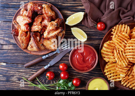 Criss Cross Pommes auf einem Ton Platten auf einem Holztisch mit Senf und Tomatensauce eintauchen, von oben, flache Ansicht legen, close-up Stockfoto