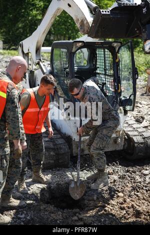 Us Marine Lance Cpl. Mitchell R. Neimann (links), schwere Ausrüstung Fahrer mit dem Ingenieur Unternehmen C, 6 Techniker, 4. Marine Logistik Gruppe, gräbt ein Loch an einer Baustelle während der Übung rote Dolch am Fort Indiantown Gap, Pa, 21. Mai 2018. Übung rote Dolch ist eine bilaterale Übung, die Marines die Möglichkeit, Taktiken, Techniken und Verfahren sowie Aufbau von Arbeitsbeziehungen mit ihren britischen Kollegen. Stockfoto