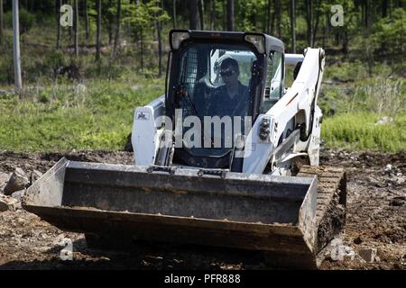 Us Marine Lance Cpl. Mitchell R. Neimann, schwere Ausrüstung Fahrer mit dem Ingenieur Unternehmen C, 6 Techniker, 4. Marine Logistics Group, betreibt ein Bobcat Bulldozer aus dem Boden auf einer Baustelle zu Level während der Übung rote Dolch am Fort Indiantown Gap, Pa, 21. Mai 2018. Übung rote Dolch ist eine bilaterale Übung, die Marines die Möglichkeit, Taktiken, Techniken und Verfahren sowie Aufbau von Arbeitsbeziehungen mit ihren britischen Kollegen. Stockfoto