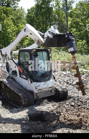 Us Marine Lance Cpl. Mitchell R. Neimann (links), schwere Ausrüstung Fahrer mit dem Ingenieur Unternehmen C, 6 Techniker, 4. Marine Logistics Group, betreibt ein Bobcat Schnecke ein Loch an einer Baustelle während der Übung rote Dolch am Fort Indiantown Gap, Pa, 21. Mai 2018 dig. Übung rote Dolch ist eine bilaterale Übung, die Marines die Möglichkeit, Taktiken, Techniken und Verfahren sowie Aufbau von Arbeitsbeziehungen mit ihren britischen Kollegen. Stockfoto