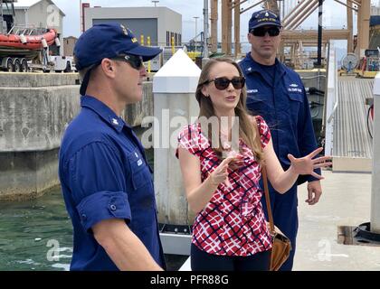 Vertreter Lauren Matsumoto, Hawaii State Repräsentantenhaus, wird vom Master Chief Petty Officer Michael Collis, Einsatzleiter, der U.S. Coast Guard Cutter Ahi (WPB 87364), auf der Basis von Honolulu, 21. Mai 2018 begrüßt. Vertreter Matsumoto kam mit der Besatzung und der Hand zu sprechen - eine Proklamation für Nationale Sicherheit Bootfahren Woche Mai 19-25, 2018 Ort liefern. Stockfoto